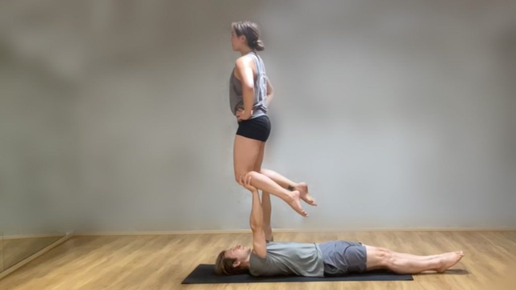 Marie balancing on her knees in Tomas' hands